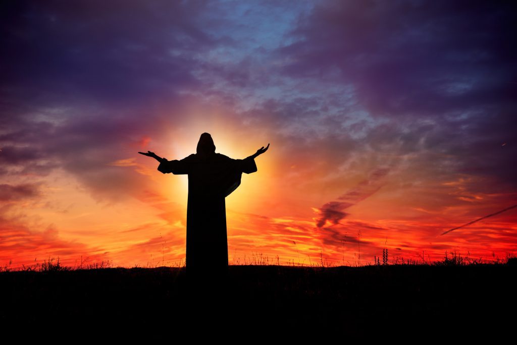 Man praying at sunset